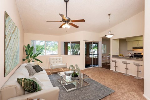 a living room with a white couch and a ceiling fan